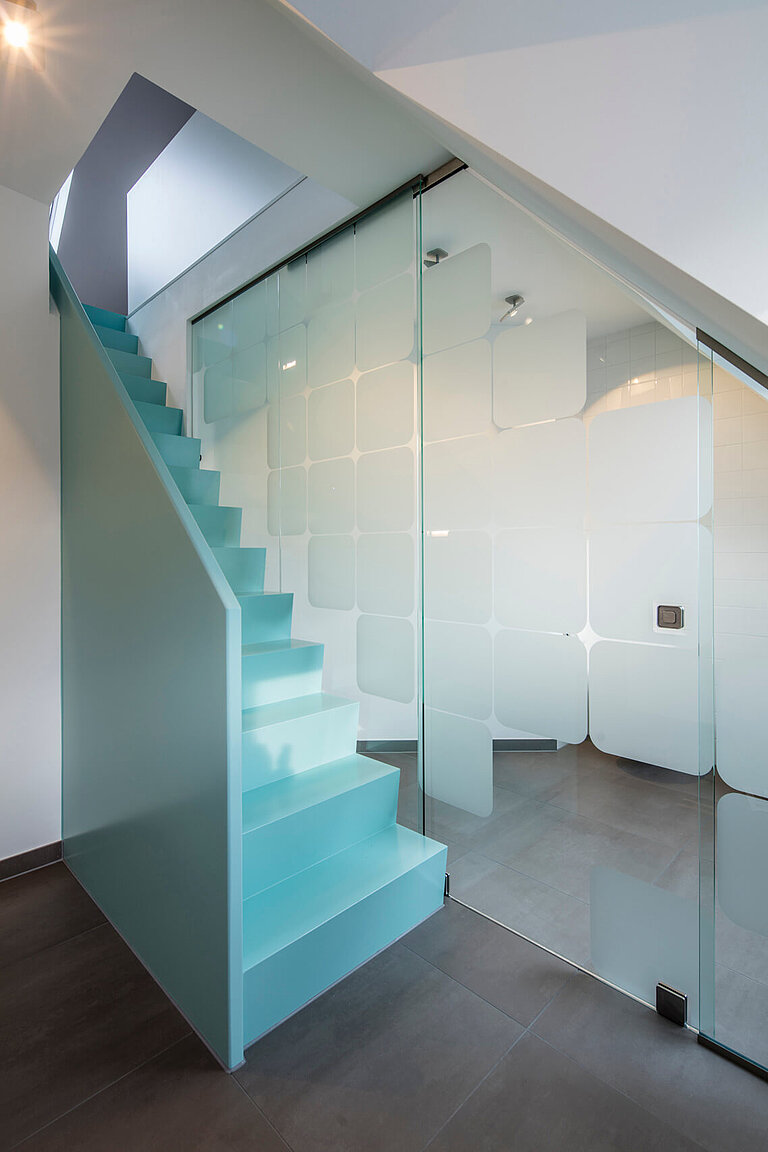Treppe ins Dachgeschoss mit Glasschiebewand.